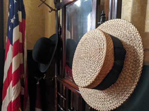 Hats hanging next to entryway mirror.