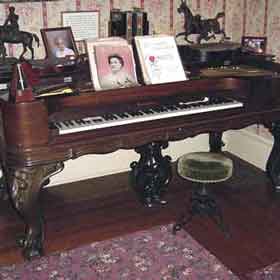 Thumbnail image of an antique baby grand piano.
